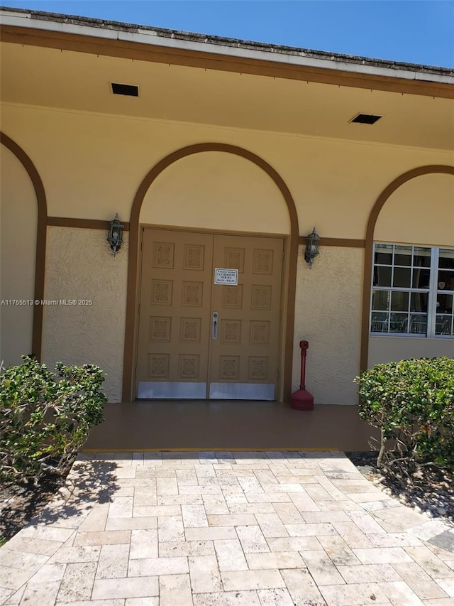 doorway to property with stucco siding