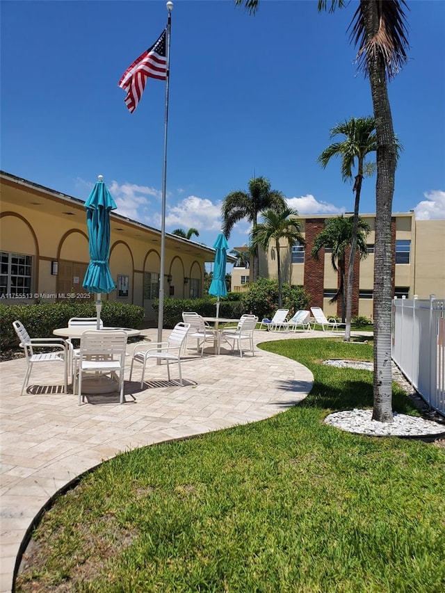 surrounding community featuring a patio, a lawn, and fence