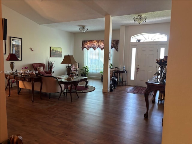 foyer with wood finished floors, baseboards, and a textured ceiling