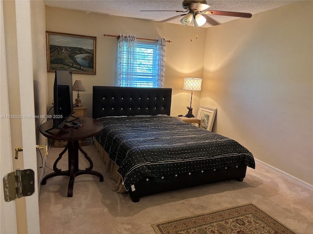 carpeted bedroom featuring baseboards, a textured ceiling, and ceiling fan