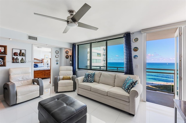 living area featuring a water view, visible vents, a ceiling fan, and light tile patterned flooring