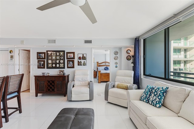 living area featuring light tile patterned floors, visible vents, and a ceiling fan