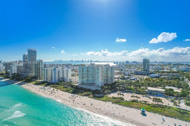 drone / aerial view featuring a beach view, a water view, and a city view