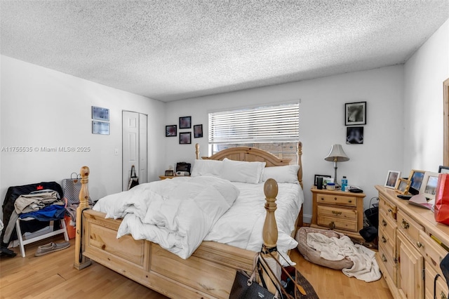 13190 SW 10th Terrace Dr Unit 13190, Miami, FL 33184 - bedroom with light wood-style floors, a textured ceiling, and a closet