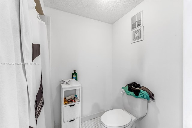 13190 SW 10th Terrace Dr Unit 13190, Miami, FL 33184 - bathroom with a textured ceiling, toilet, tile patterned floors, and baseboards
