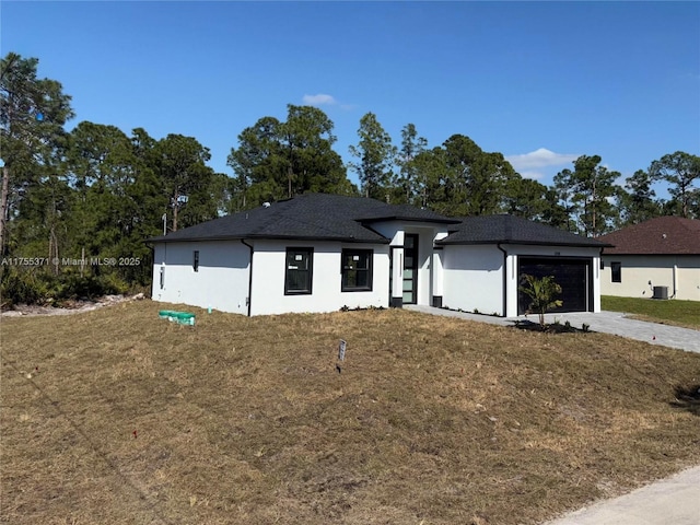 view of front of home featuring a garage, a front lawn, and concrete driveway