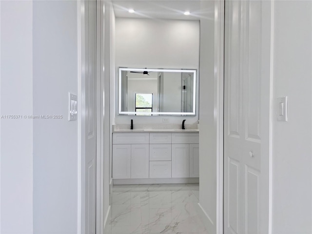 bathroom featuring recessed lighting, marble finish floor, a sink, and double vanity