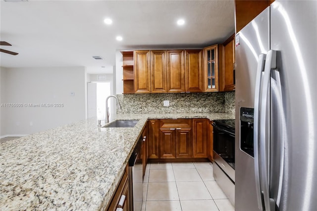 kitchen with light tile patterned flooring, a sink, visible vents, appliances with stainless steel finishes, and brown cabinets