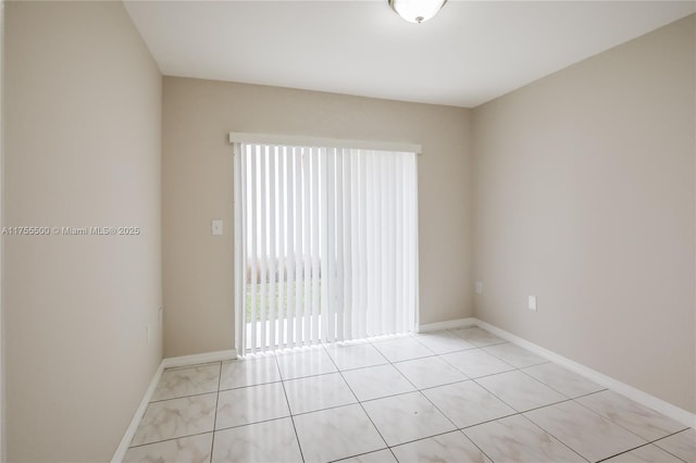 spare room with light tile patterned floors and baseboards