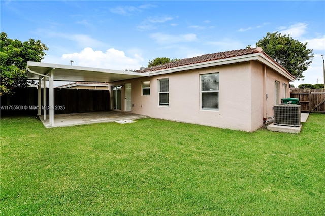 rear view of house featuring a yard, a patio area, central AC, and fence