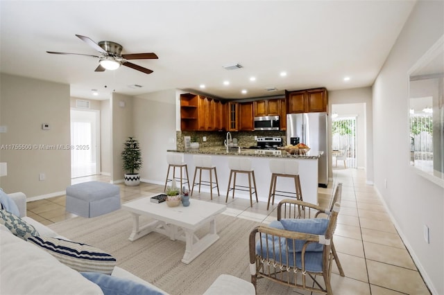 living area featuring light tile patterned floors, baseboards, visible vents, and recessed lighting