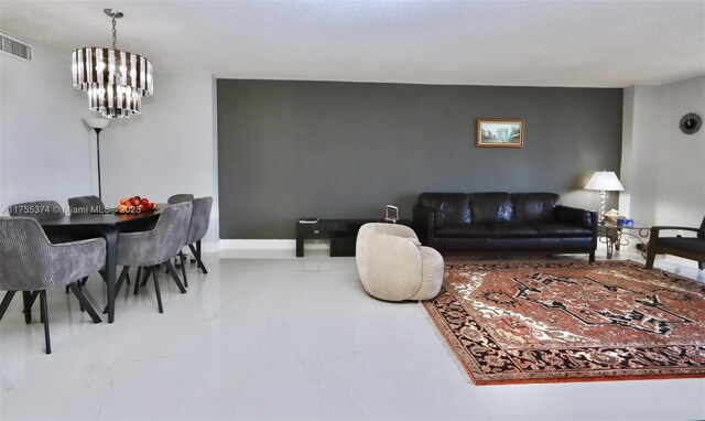 living room with a chandelier, visible vents, and baseboards