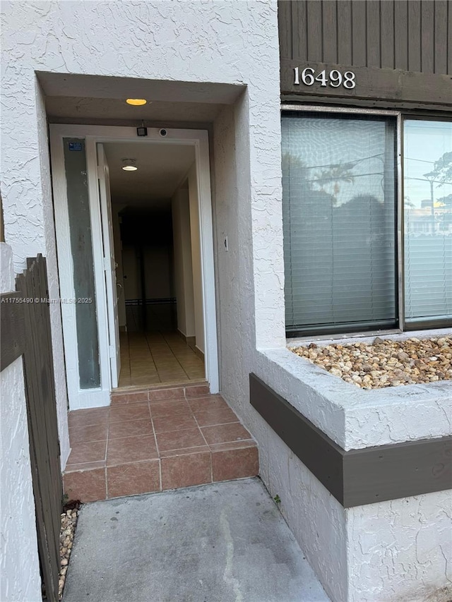 doorway to property featuring stucco siding