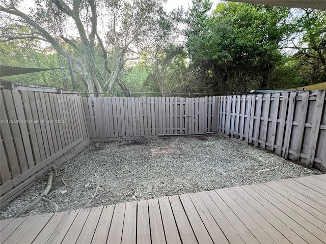 wooden terrace with a fenced backyard