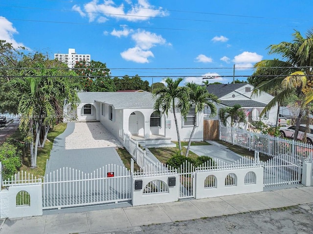 view of front of home featuring a fenced front yard, a gate, and stucco siding