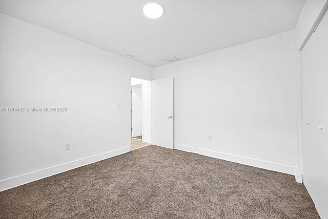 unfurnished bedroom featuring a closet, baseboards, and carpet flooring