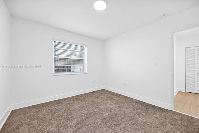 carpeted empty room with baseboards