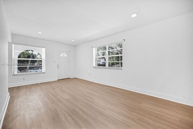 empty room with recessed lighting, baseboards, and light wood finished floors