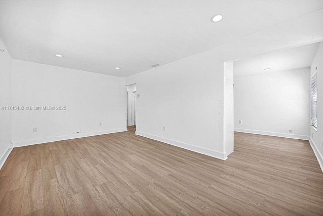 empty room with recessed lighting, baseboards, and wood finished floors