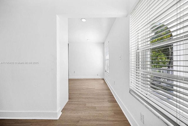 corridor featuring baseboards and wood finished floors