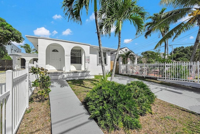 view of front of home featuring covered porch, a fenced front yard, and stucco siding