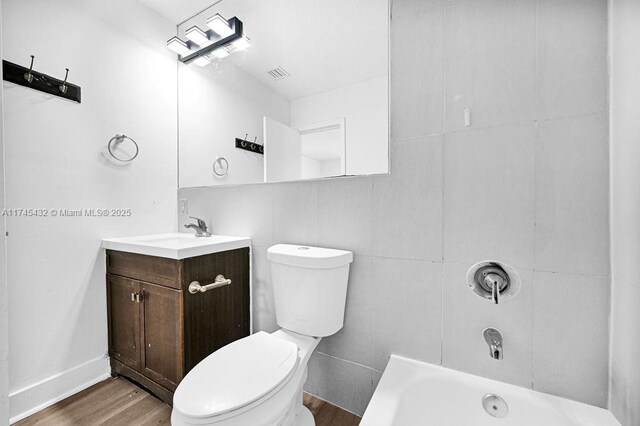 bathroom with toilet, shower / bath combination, wood finished floors, vanity, and visible vents