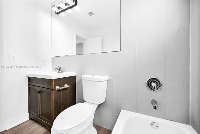 bathroom with toilet, visible vents, wood finished floors, and vanity