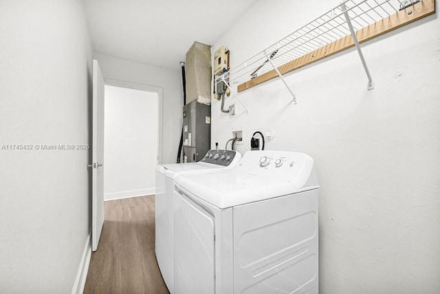 washroom with laundry area, baseboards, separate washer and dryer, and wood finished floors