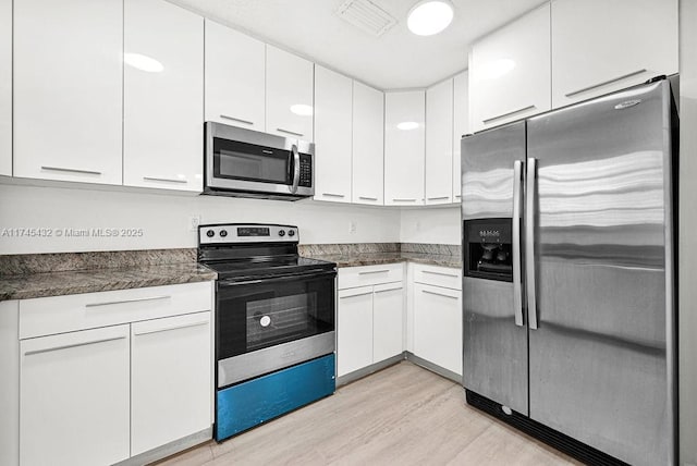 kitchen featuring stainless steel appliances, light wood-type flooring, and white cabinets