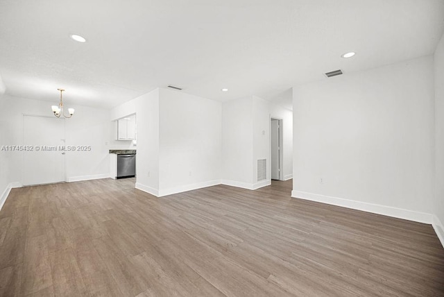 unfurnished living room with visible vents, a chandelier, wood finished floors, and recessed lighting