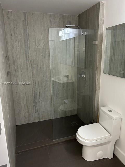 bathroom with walk in shower and toilet