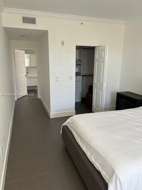 bedroom featuring visible vents, a closet, baseboards, and crown molding