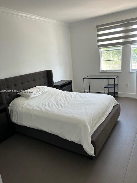 bedroom with baseboards and ornamental molding