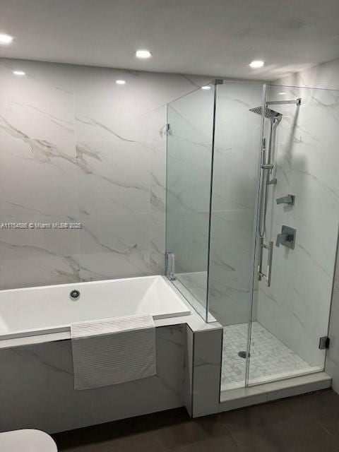 full bathroom with a garden tub, a marble finish shower, and recessed lighting