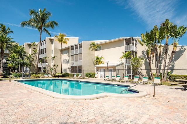 community pool with fence and a patio