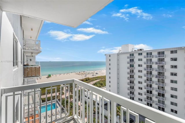 balcony with a water view and a view of the beach