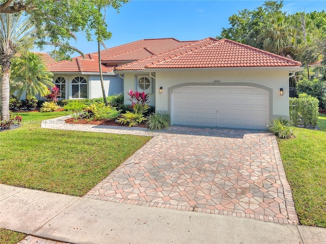 mediterranean / spanish-style house featuring a tile roof, stucco siding, an attached garage, driveway, and a front lawn