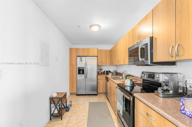 kitchen featuring light tile patterned floors, electric panel, appliances with stainless steel finishes, light countertops, and a sink