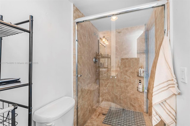 bathroom featuring a shower stall and toilet