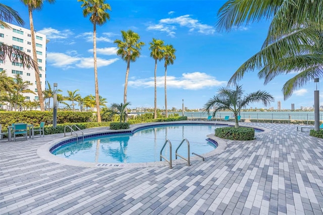 pool with a patio and fence