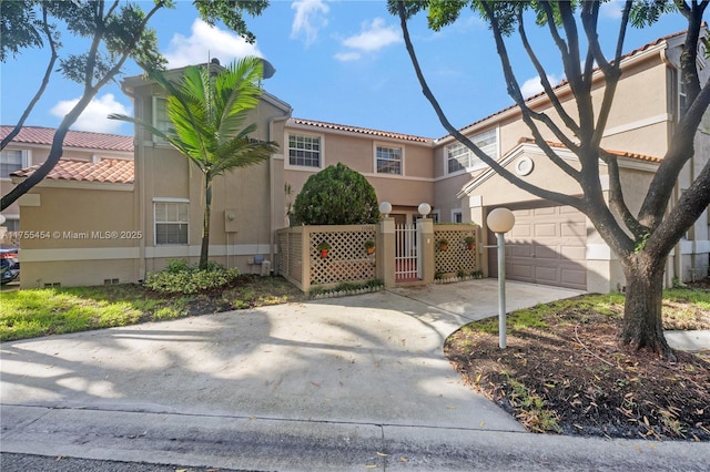 view of front of home with concrete driveway, a tile roof, fence, and stucco siding