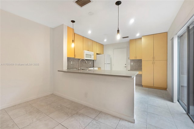 kitchen with visible vents, decorative backsplash, a sink, white appliances, and a peninsula