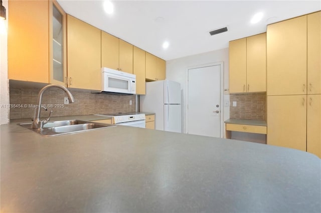 kitchen with white appliances, visible vents, a sink, and cream cabinetry