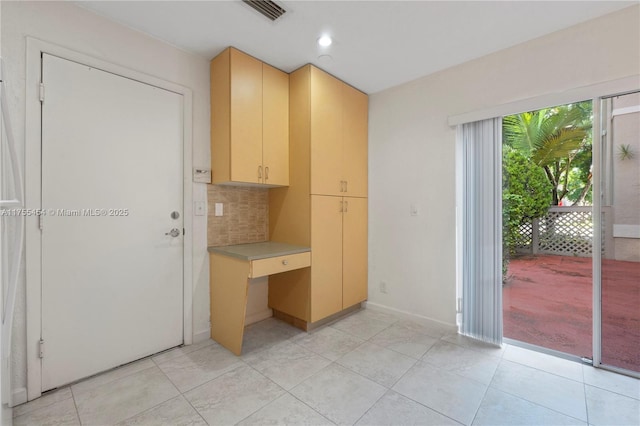 kitchen featuring light countertops, tasteful backsplash, light tile patterned flooring, and visible vents