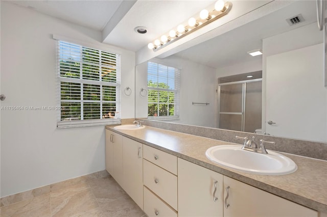 bathroom with double vanity, a stall shower, visible vents, and a sink