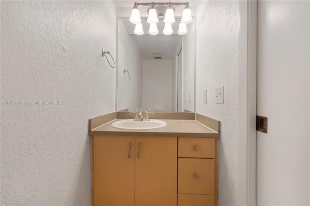 bathroom featuring a textured wall and vanity