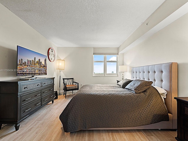 bedroom with light wood-type flooring and a textured ceiling