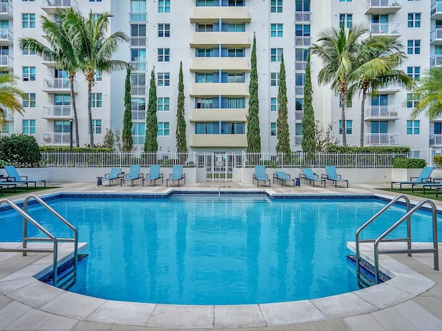 community pool featuring a patio area and fence