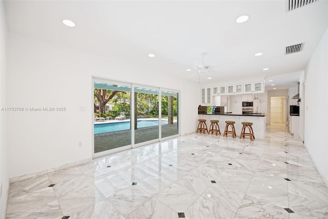 unfurnished living room featuring recessed lighting and visible vents