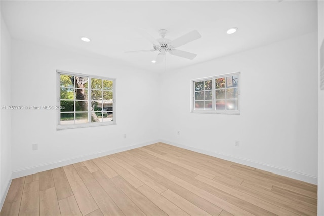 spare room featuring recessed lighting, a healthy amount of sunlight, light wood-style flooring, and baseboards